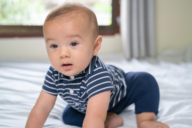 Foto ein süßer junge sitzt zu hause im bett