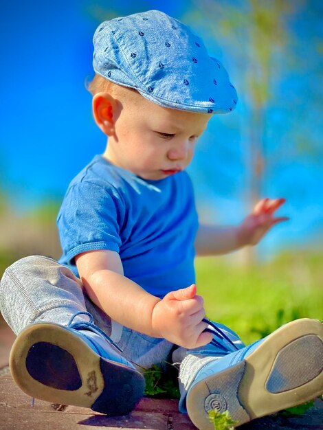 Ein süßer Junge spielt mit einem blauen Ball