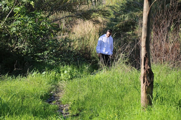 Ein süßer kleiner Junge geht im Outdoor-Waldpark spazieren