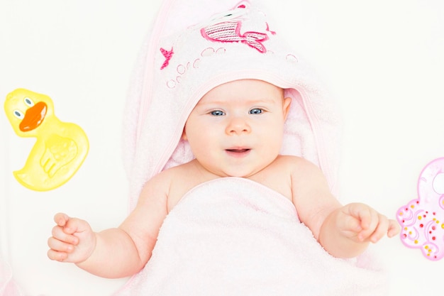 Ein süßes Baby liegt nach einem Bad in einem rosa Handtuch Baden von Neugeborenen