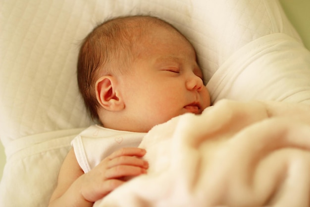 Ein süßes Baby schläft im Bett.
