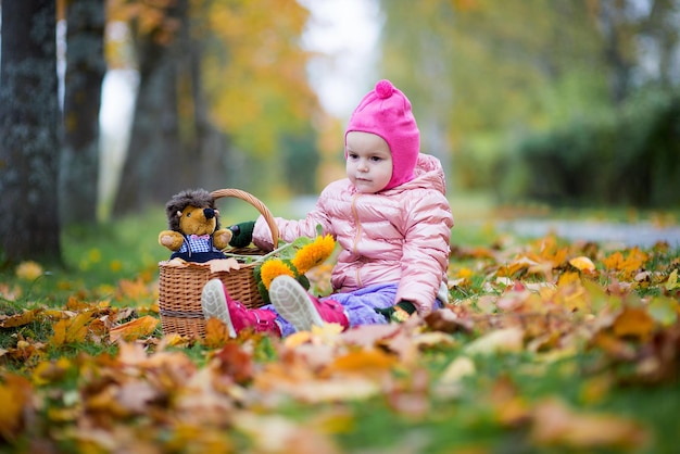 Ein süßes Baby sitzt auf dem Feld im Park