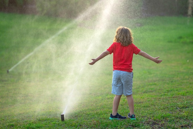 Foto ein süßes kleines kind spielt an einem sommertag im garten, ein kind genießt den sommer im hinterhof, ein kleiner junge amüsiert sich.