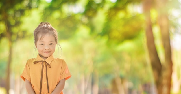 Ein süßes kleines Mädchen im grünen Park an einem sonnigen Tag