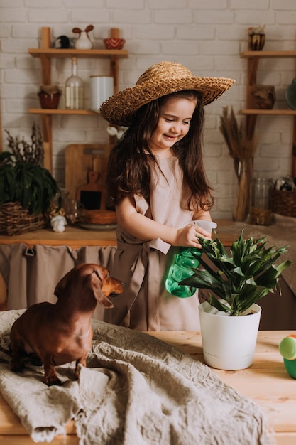 Ein süßes kleines Mädchen pflanzt und gießt zu Hause eine Blume in einen Topf. Ein kleiner Sommerbewohner kümmert sich um die Blumen zu Hause Tag der Erde