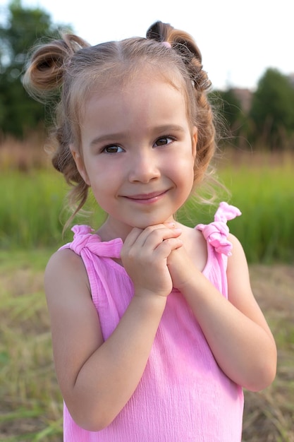 Ein süßes kleines Mädchen sitzt auf dem Rasen auf dem Land Modeschönheit Sommer