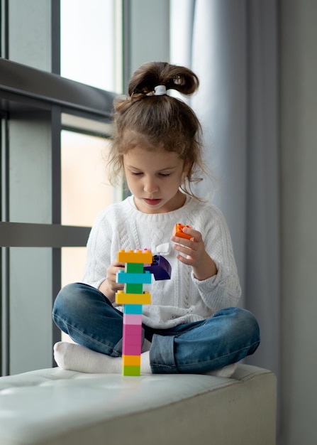 Ein süßes kleines Mädchen spielt Baukasten. Kindheit. Entwicklung.