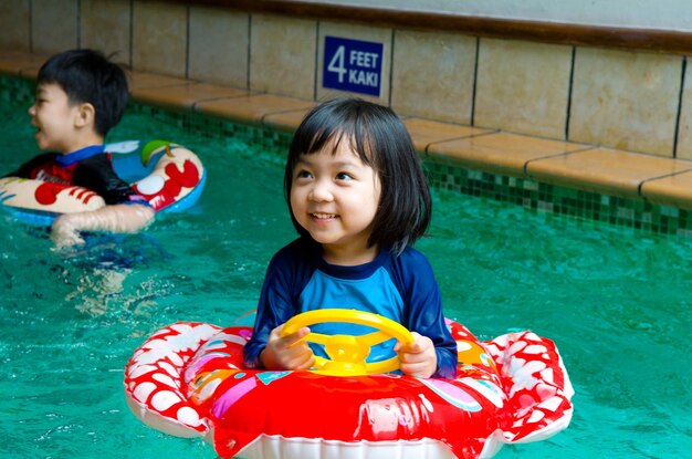 Ein süßes lächelndes Mädchen im Schwimmbad