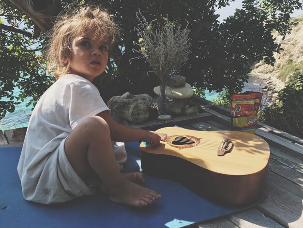 Foto ein süßes mädchen sitzt an der gitarre