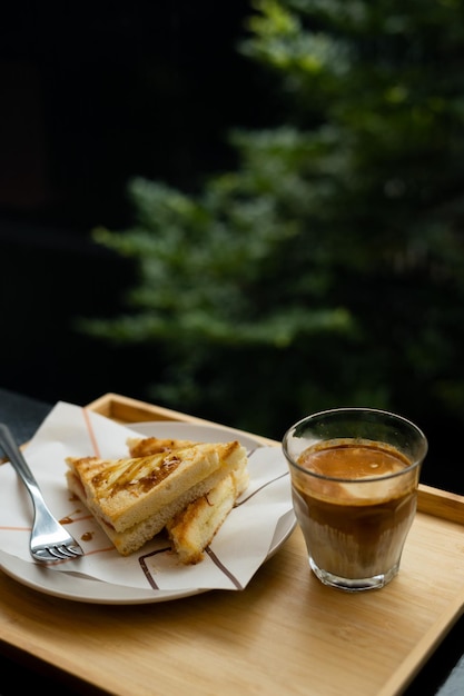 Ein Tablett mit einem Teller mit Essen und einem Glas Kaffee darauf