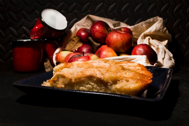 Ein Tablett mit Essen mit Äpfeln darauf und einer rot-weißen Tasse dahinter.