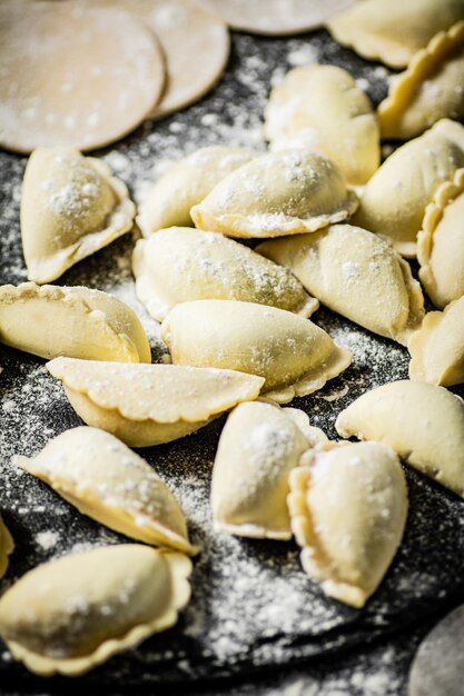 Ein Tablett mit hausgemachten Ravioli mit Puderzucker darauf.