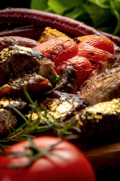 Ein Tablett mit verschiedenen Grillprodukten, gegrilltes Steak, gegrillte Würstchen, gegrilltes Gemüse, verschiedene Fleischsorten