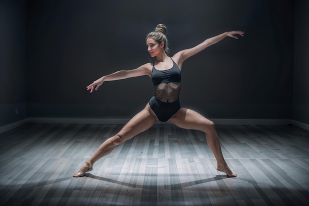 Foto ein tänzerin in einem schwarzen leotard und shorts in einer lunge-position in einem tanzstudio