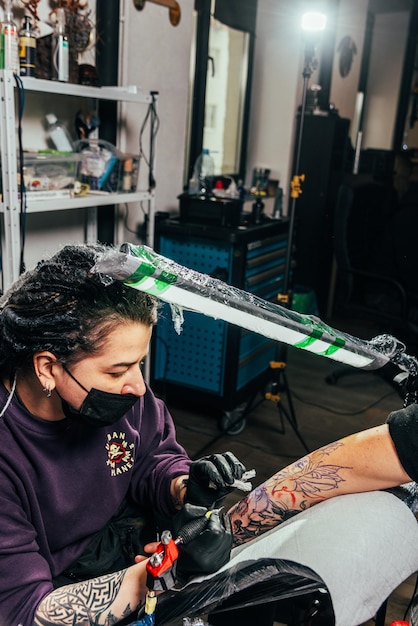 Ein Tätowierer macht ein Tattoo in einem Salon
