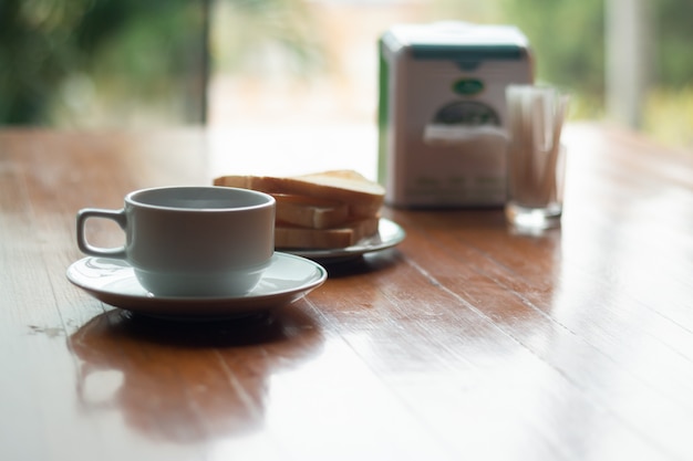 Ein Tasse Kaffee mit Toast auf einem Holztisch für Frühstückszeit