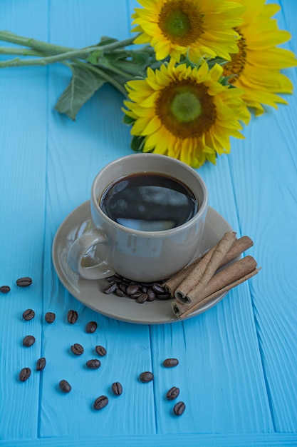 Ein Tasse Kaffee-Zimt und eine Sonnenblume auf einem blauen Hintergrund.