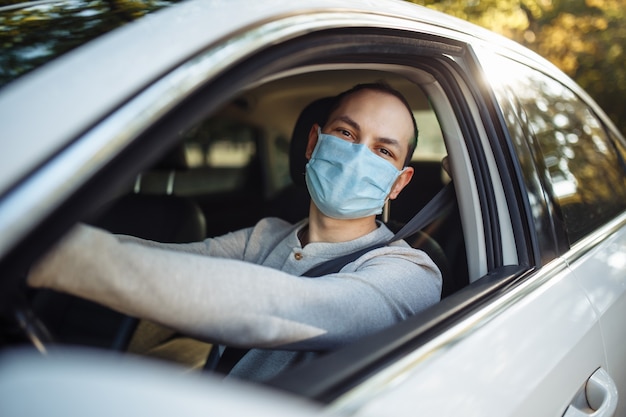 Ein Taxifahrer fährt ein Auto mit medizinischer Maske während des Ausbruchs des Coronavirus.