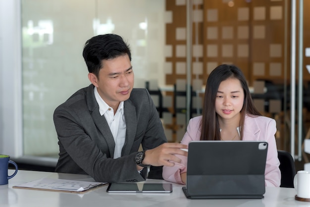 Ein Team aus Geschäftsmann und Geschäftsfrau arbeitet zusammen Brainstorming und analysiert Ihre Arbeit im Büro.