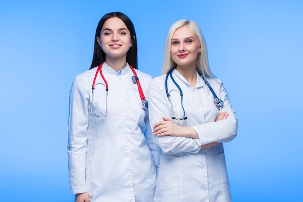 Ein Team junger Bewohner. Arzt, Krankenschwester und Chirurg im blauen Hintergrund. Eine Gruppe Medizinstudenten verschiedener Nationalitäten sucht in der Zelle