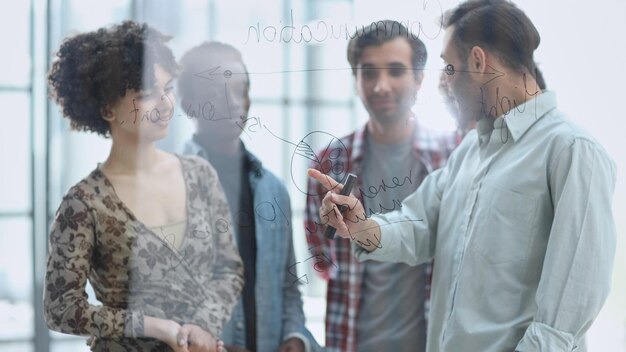 Foto ein team junger designer, die in einem modernen büro notizen auf glas kleben