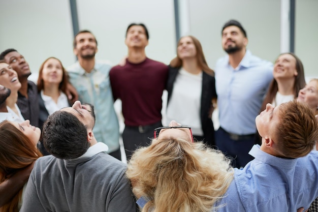 Ein Team junger Leute, die sich im Büro umarmen