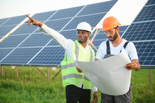 Ein Team von Arbeitern aus verschiedenen Rassen auf einem Feld mit Solarpanelen