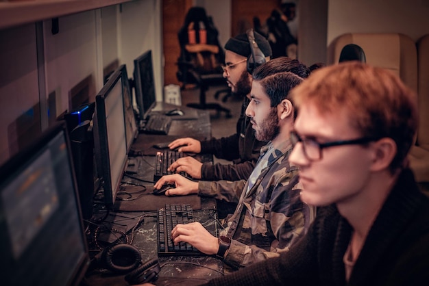 Ein Team von jugendlichen Spielern spielt in einem Gaming-Club ein Multiplayer-Videospiel auf dem PC.