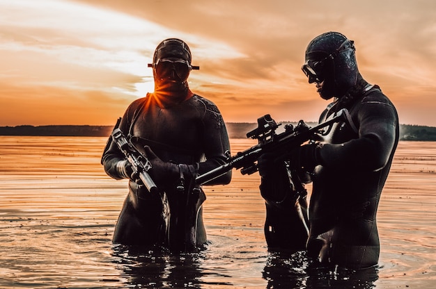 Ein Team von Kämpfern einer Spezialeinheit bewegt sich auf dem Wasser, um die Aufgabe zu erfüllen. Das Konzept der Instabilität, Militäroperationen, der Kalte Krieg. Gemischte Medien