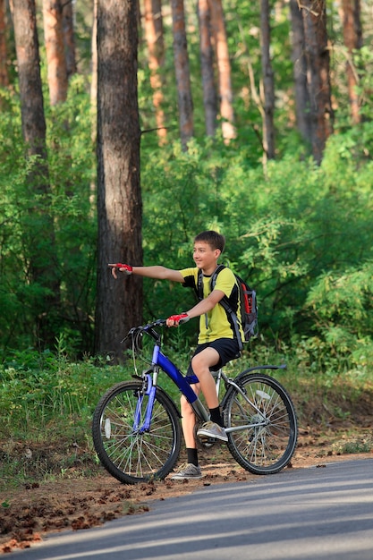 Ein Teenager auf einem Fahrrad im Wald unterwegs