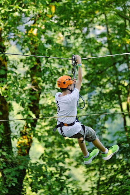 Ein Teenager auf einer Seilrutsche amüsiert sich im Outdoor-Extrem-Abenteuerpark Aktive Kindheit in der Natur