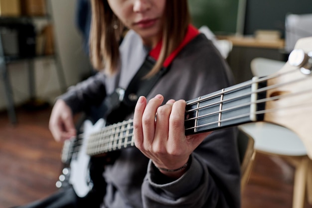 Ein Teenager, das Bassgitarre spielt