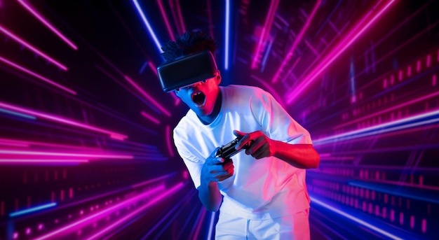 Ein Teenager hält einen Joystick und trägt eine Schutzbrille, während er Spiele spielt.