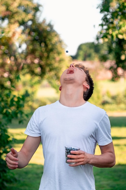 Foto ein teenager isst blaubeeren, während er auf dem feld steht