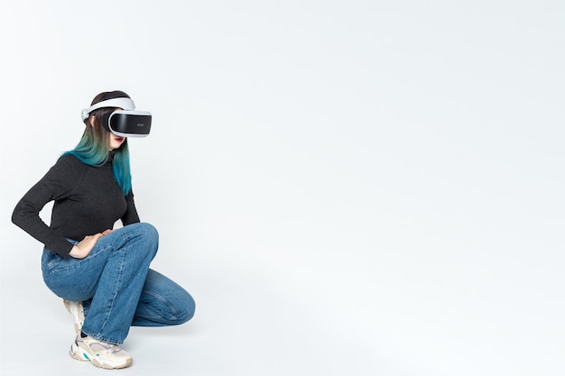 Ein Teenager-Mädchen in einem Vr-Helm spielt im virtuellen Universum, das auf einem weißen Hintergrund kopiert wird. Das Konzept des virtuellen Universums Lifestyle im virtuellen Raum