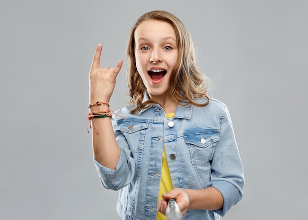 ein Teenager-Mädchen macht ein Foto mit einem Selfie-Stick