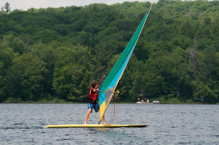 Foto ein teenager paddleboardet auf einem fluss gegen bäume
