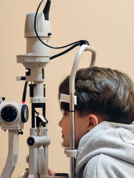 Ein Teenager-Patient verwendet spezielle ophthalmologische Geräte, um sein Sehvermögen in einem modernen zu überprüfen