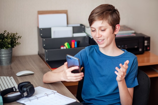 Ein Teenager telefoniert mit seinem Handy mit seinen Freunden, Klassenkameraden und Verwandten.