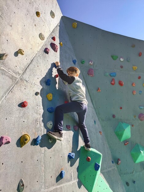 Foto ein teenager trainiert und klettert auf eine kletternmauer, ein beispiel für ein aktives sportleben