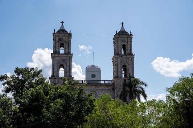 Foto ein teil der wunderschönen kathedrale von valladolid in mexiko, umgeben von bäumen, in denen sich die türme mit dem glockenturm hervorheben