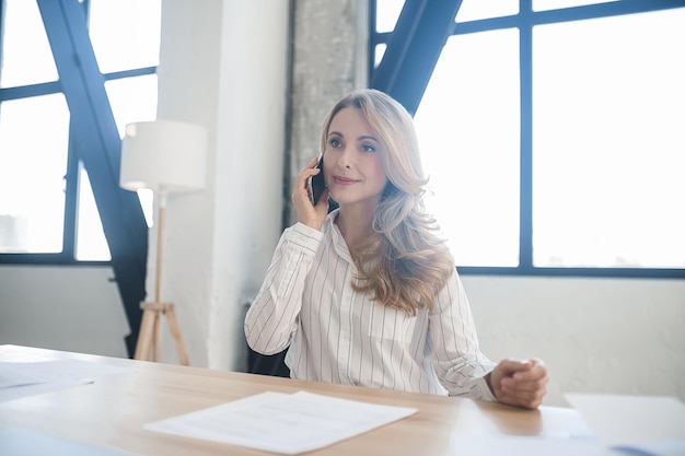 Ein Telefonanruf Eine alleinstehende Geschäftsfrau in ihrem Büro, die am Telefon spricht