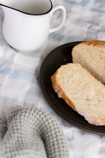 Ein Teller Brot auf einem Tisch mit einem Becher daneben.