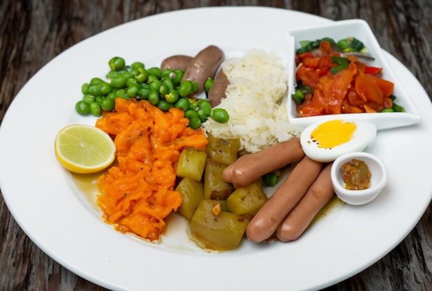 Ein Teller mit Essen, einschließlich Bohnen, Reis und Gemüse.