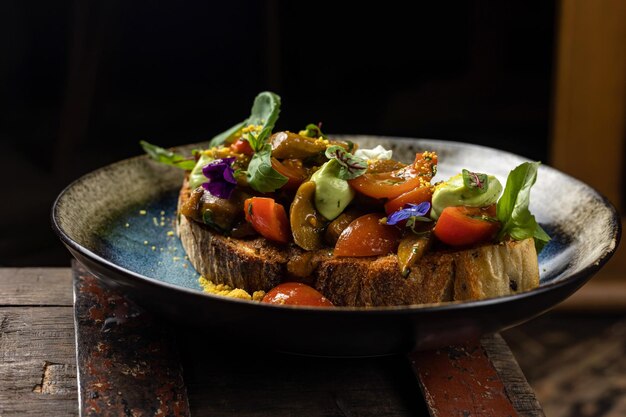 Ein Teller mit Essen mit einer Scheibe Toast mit Gemüse darauf