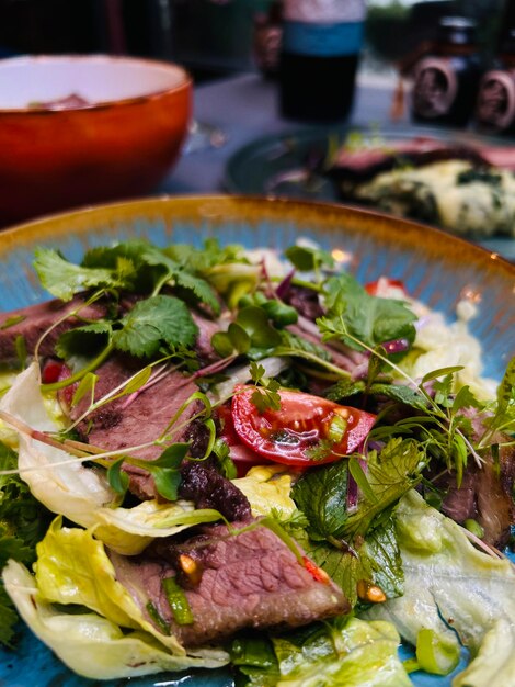 Foto ein teller mit fleisch und gemüse mit einer sauce als beilage.