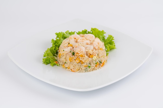 Foto ein teller mit gebratenem reis mit garnelen und einem salat darüber.