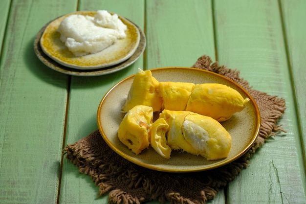 Ein Teller mit gelben Durian-Fruchten, hölzerner Tisch, köstliche tropische Früchte aus Indonesien