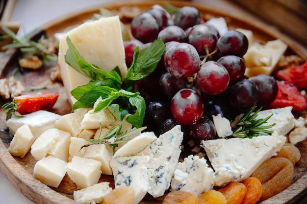 Ein Teller mit Käse und Obst mit Trauben darauf