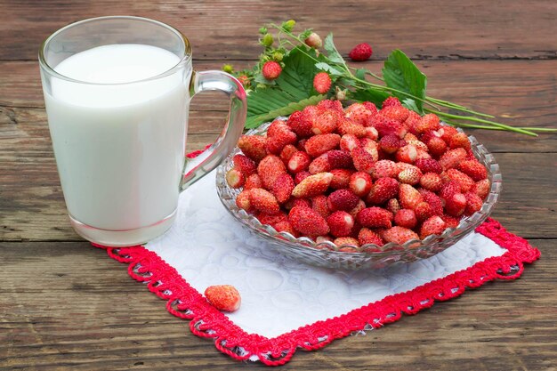 Ein Teller mit reifen duftenden Erdbeeren und Milchkrug